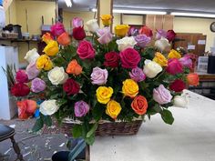 a basket filled with lots of different colored roses on top of a white countertop