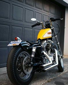 a yellow and black motorcycle parked in front of a garage