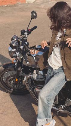 a person sitting on a motorcycle in the street