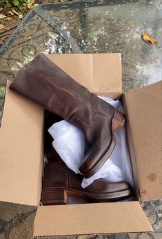 a pair of brown boots in a cardboard box