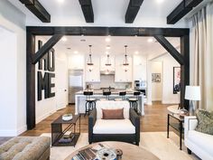 a living room filled with furniture next to a kitchen