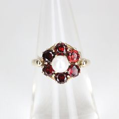 A vintage 9 carat yellow gold cultured pearl and garnet set dress ring. Featuring a central 4.8mm round cultured pearl surrounded by six deeply coloured garnets  - 3.5mm round each approx.   Hallmarked: London: 1964 Rings Size: J  -  4 5/8 Weight: 3.1 grams Condition: Please refer to all images for overall condition. Should you have any questions, please don't hesitate to contact me SHIPPING IN AUSTRALIA If you would like to reduce your shipping costs, please let me know as I can send your items Vintage White Ruby Ring For Formal Occasions, Elegant Red Pearl Ring For Anniversary, Garnet Dress, Dress Ring, Classy Jewelry, Dress Rings, Dream Jewelry, Cultured Pearls, Rings Statement