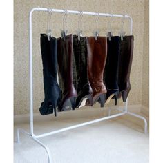 four pairs of boots are hanging on a rack