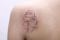 a woman's shoulder with a black line drawing of two women on the side