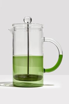 a glass tea pot filled with green liquid