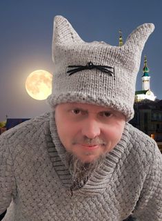 a man wearing a knitted hat with a cat on it