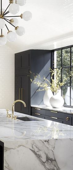 an image of a kitchen with black cabinets and white marble counter tops on instagram