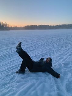 a person laying in the snow on their back