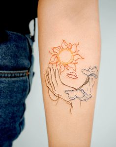 a woman's arm with a sun and hands tattoo on the left side of her body