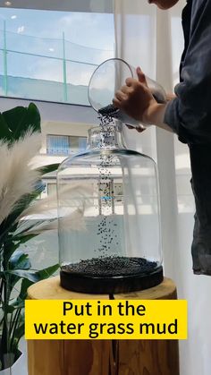 a person pouring water into a glass container