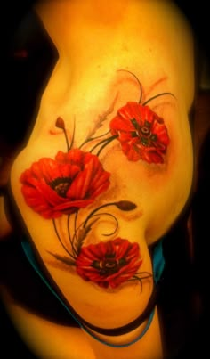 a woman's stomach with red flowers on it and an artistic design in the middle