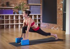 a woman is doing yoga on two blue blocks