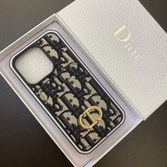 an open box with a black and white phone case in the inside, on top of a leather surface