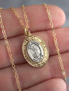 "Oval Saint Michael pendant is 925 Sterling Silver, two tone silver with gold with smooth gold backside. SUPERB QUALITY! Pendant Size 23x16mm. Chain shown is 14kt gold filled shiny cable chain necklace with spring clasp. May choose this chain in 925 Sterling Silver. Model is wearing 16\" length in photos. Comes in a gift box ready to present." Catholic Jewelry Necklace, St Michael Necklace, 14kt Gold Jewelry, St Michael Pendant, Clean Sterling Silver, Silver Model, Angel Jewelry, Saint Michael, Catholic Jewelry