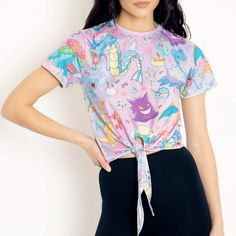 a woman wearing a pink shirt and black pants with an unicorn print on the front