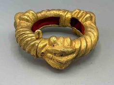 This old hinged bracelet is an authentic object of Ashanti royal regalia. It was made for the exclusive use of the Ashanti royal family and was only ever used by them. As such it is an extraordinary and genuine object regardless of the quality of the gold itself. We have been buying and selling African "gold" items for many years. In that time we have learned a lot about gold around the world. Different cultures have different standards by which to judge the quality of gold. In America we are satisfied with 14 karat gold jewelry. In Europe gold jewelry has to be at least 18 karat. In Asia anyone selling gold jewelry that is less than 22 karat would be thought of as a charlatan. But in Africa, there is no karat standard for gold objects of any kind. It's possible to find higher karat items Ancient Style Collectible Yellow Gold Jewelry, Collectible Ancient Style Yellow Gold Jewelry, Traditional Ankh Collectible Jewelry, Luxury Ancient Collectible Jewelry, Ancient Egyptian Jewelry Ancient Aura Jewelry, Sell Gold, Hinged Bracelet, Wedding Jewelry Bracelets, Wedding Bracelet