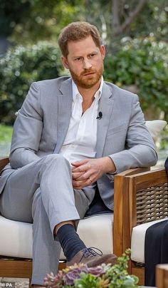 two men sitting in chairs talking to each other