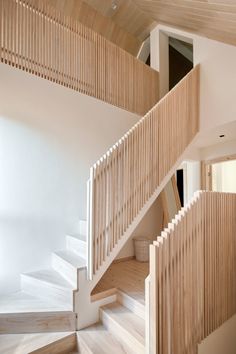 a wooden staircase with white walls and wood flooring