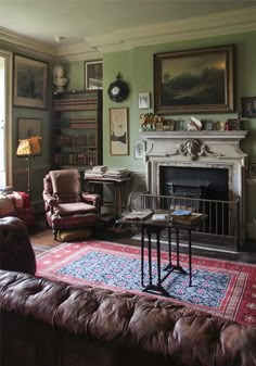 a living room filled with furniture and a fire place next to a painting on the wall