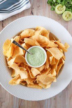 a white plate topped with chips and guacamole