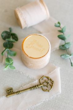 a key to the wedding is placed next to some thread spools and twine