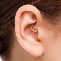 a woman's ear with a small gold hoop