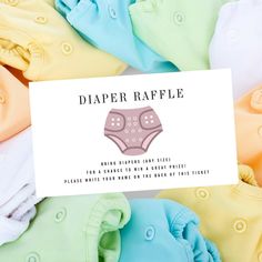 diaper raffle coupon card sitting on top of several baby ones in different colors