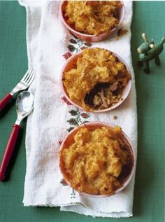 three bowls filled with food sitting on top of a table next to a fork and spoon