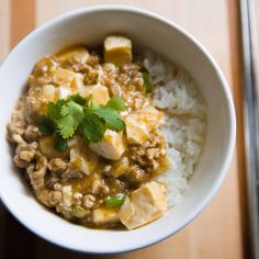 a white bowl filled with rice and meat