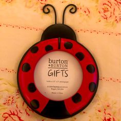 a red and black ladybug shaped plate with the words burton burton gifts on it