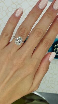 a woman's hand with pink manies and a diamond ring on her finger