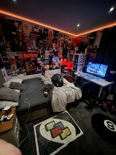 a bed room with a neatly made bed next to a tv and a large screen