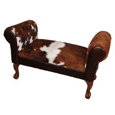 a brown and white cowhide chair with wooden legs