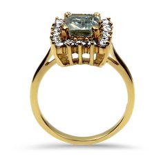 Exuding refinement, this 18K yellow gold ring is adorned with an emerald-cut Aquamarine weighing 1.10cts. The aquamarine, boasting a very slightly greenish-blue hue, measures 7.50 x 6.05 x 3.23mm and is set with four prongs. Enhancing its allure is a rectangular halo of 18 full-cut diamonds, collectively weighing 0.54ct., with VS to SI internal clarities and "near colorless" shades of "H" to "I". The open-backed mounting with gallery-worked undercarriage allows light to play through, ensuring go Gold Halo Emerald-cut Emerald Ring, Yellow Gold Emerald-cut Blue Topaz Ring, Yellow Gold Blue Topaz Rings With Emerald Cut, Yellow Gold Emerald Cut Blue Topaz Rings, Yellow Gold Ring With Green Amethyst And Accent Stones, Gold Emerald Cut Gemstone Halo Ring, Gold Emerald Cut Ring With Halo, Gold Rings With Halo Setting And Blue Topaz, Formal Emerald Cut Green Topaz Ring