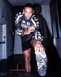 a man sitting on top of a skateboard next to a pair of shoes in a room