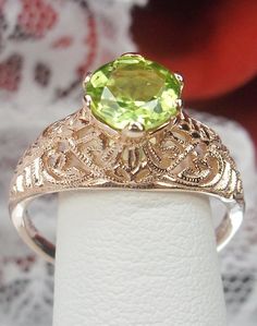 Natural Green Peridot Ring Corset Design#199 Custom Made This is a stunning Art Deco reproduction in sterling silver and rose gold plating filigree with a 1ct natural peridot. The peridot is 8mm in diameter. The inside of the band is marked 925 for sterling. Notice the beautiful craftsmanship of the rose gold filigree setting and band. This is a ornate and detailed ring. This is a lovely rendition of an antique filigree ring; and it is ready to wear. A gift ring box is included for safe keeping. Green Oval Filigree Ring For Wedding, Green Filigree Ring With Intricate Design For Anniversary, Oval Peridot Jewelry For Wedding, Antique May Birthstone Rings For Wedding, Elegant Green Filigree Ring For Anniversary, Wedding Filigree Ring With May Birthstone, Green Filigree Ring With Intricate Design For Wedding, Green Filigree Ring For Wedding, Antique May Birthstone Wedding Rings