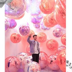 a man is standing in front of some balloons