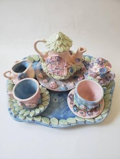 a tea set on a tray with cups and saucers