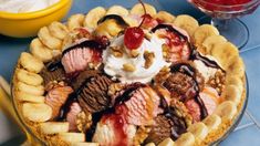 a pie with ice cream, bananas and other toppings on it sitting on a table