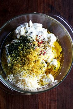 a glass bowl filled with food on top of a wooden table