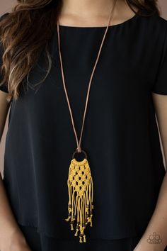 a woman wearing a black top with a yellow tassel necklace on it's neck