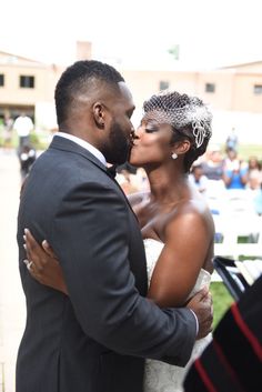 a bride and groom kissing in front of an audience