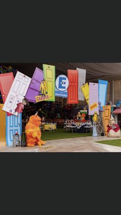 there are many colorful kites on display at this outdoor event in the grass with tables and chairs around them