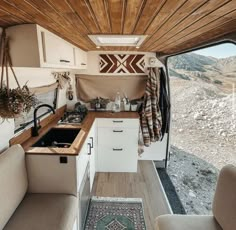 the interior of an rv with wood paneling on the ceiling and kitchen in the back