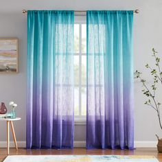 blue and purple ombreed curtains hanging in front of a window with potted plant