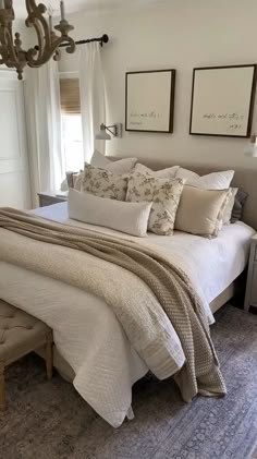 a large bed sitting in a bedroom next to two pictures on the wall above it