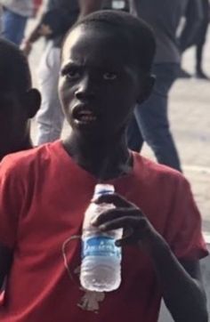 a young boy holding a bottle of water