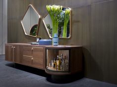 a table with some vases and bottles on it next to a wall mounted mirror