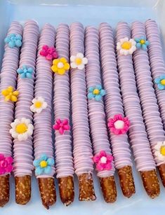 there are many candy sticks decorated with flowers on the top one is purple and has white frosting