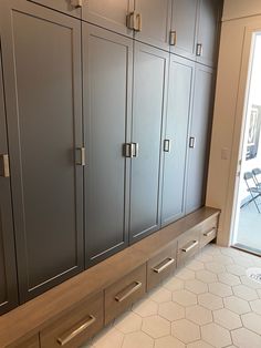 a kitchen with gray cabinets and white tile flooring next to a sliding glass door